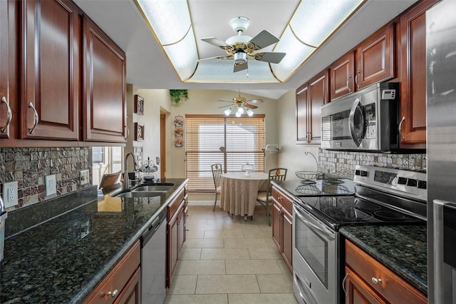 kitchen featuring backsplash, sink, light tile patterned floors, and appliances with stainless steel finishes