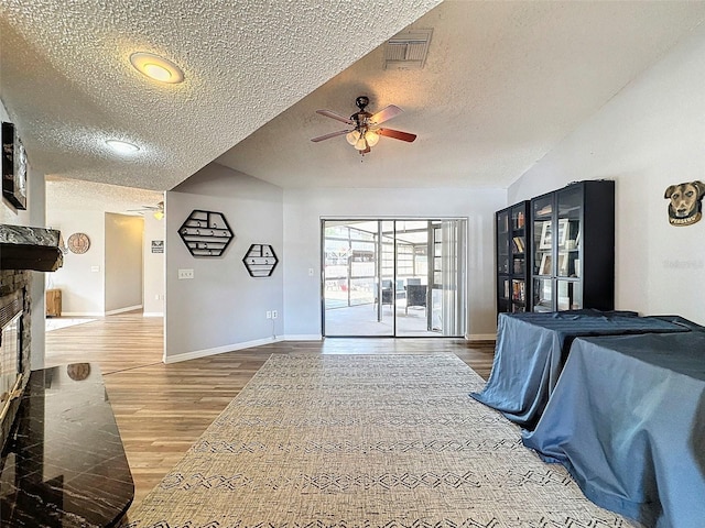 interior space featuring ceiling fan, a textured ceiling, and wood-type flooring