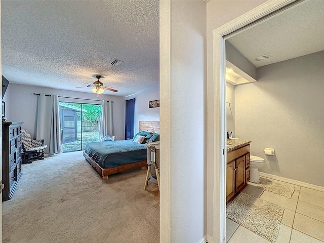 bedroom featuring ceiling fan, light colored carpet, a textured ceiling, and access to exterior