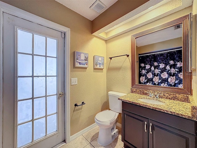 bathroom with toilet, vanity, tile patterned floors, and a healthy amount of sunlight