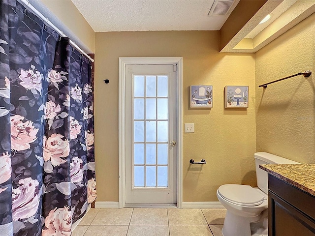 bathroom featuring a textured ceiling, vanity, tile patterned floors, and toilet