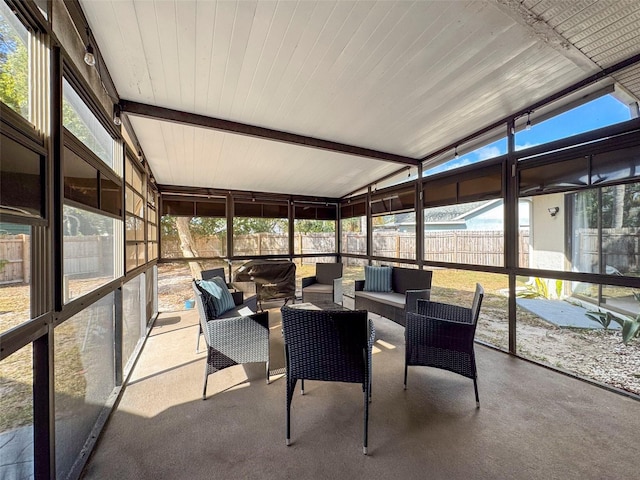 sunroom / solarium featuring vaulted ceiling and a healthy amount of sunlight