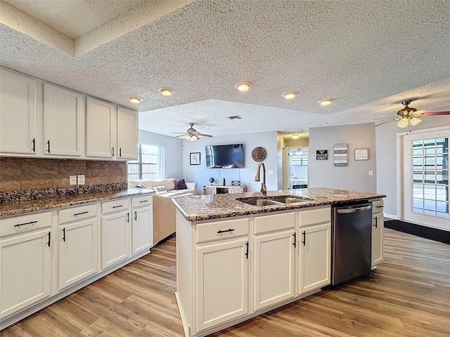 kitchen with white cabinetry, a center island with sink, dishwasher, and sink