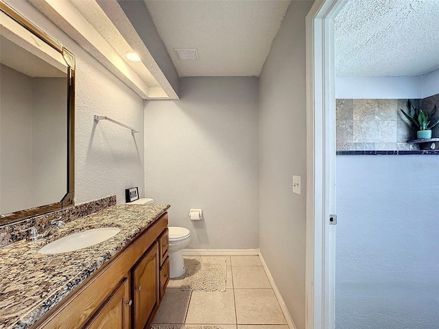 bathroom featuring a textured ceiling, vanity, and toilet