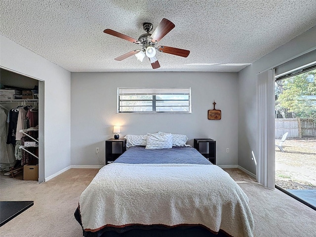 bedroom featuring a textured ceiling, access to outside, ceiling fan, a closet, and light colored carpet