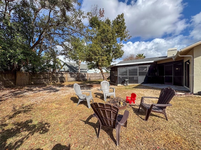 view of yard with an outdoor fire pit and a sunroom