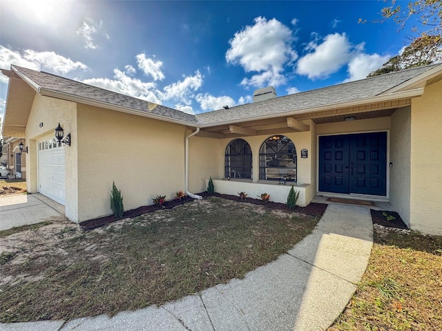 property entrance featuring a yard and a garage