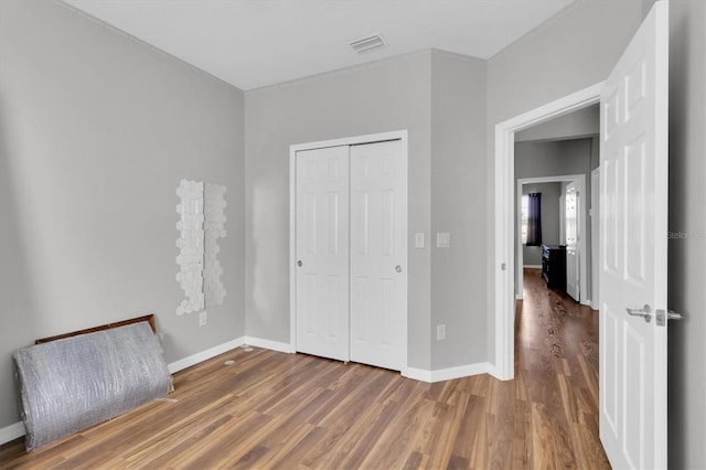 unfurnished bedroom with wood-type flooring and a closet