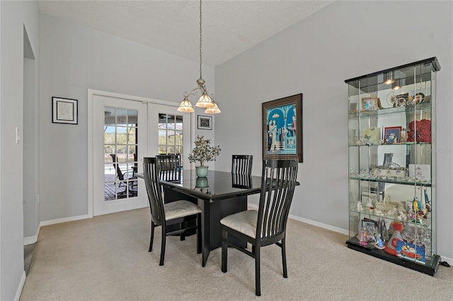 carpeted dining space with french doors, lofted ceiling, and a textured ceiling