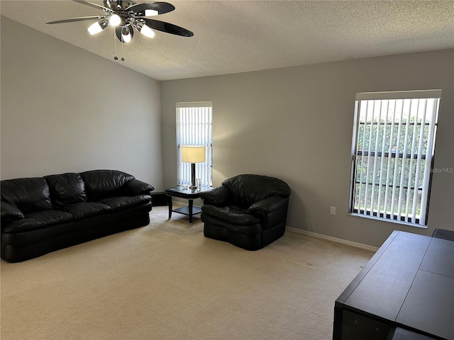 living room featuring ceiling fan, light colored carpet, and a textured ceiling