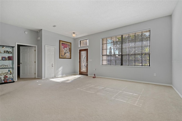 interior space with light colored carpet and a textured ceiling