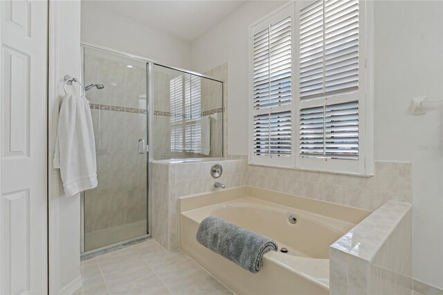 bathroom with independent shower and bath and tile patterned floors