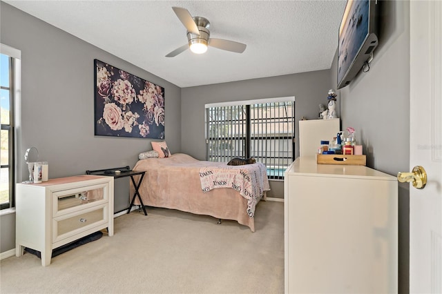 bedroom featuring multiple windows, ceiling fan, and light carpet