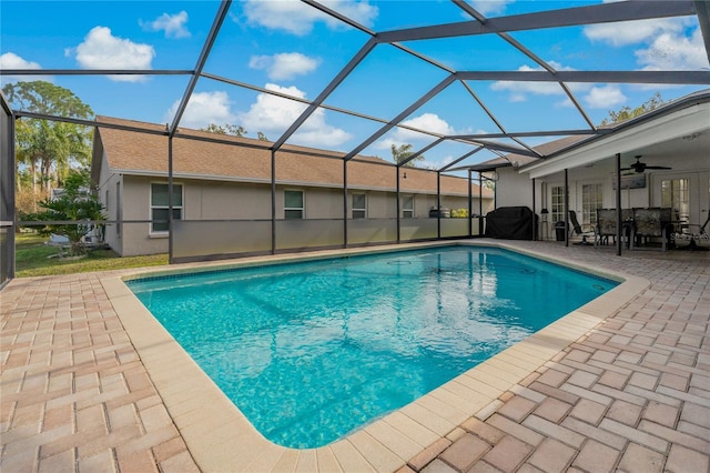 view of swimming pool featuring a lanai, ceiling fan, and a patio area