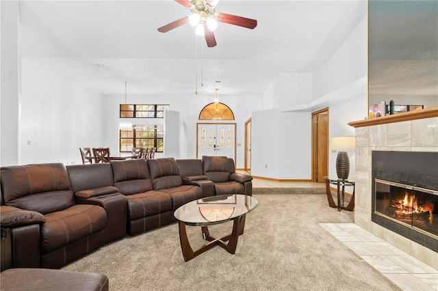 carpeted living room with ceiling fan and a tiled fireplace