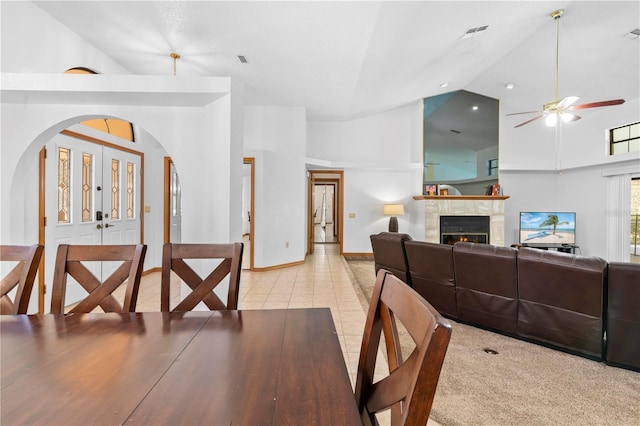 7443 Oak Tree Ln, Spring Hill, FL 34607 - dining room featuring ceiling fan, high vaulted ceiling, arched walkways, a warm lit fireplace, and light tile patterned floors