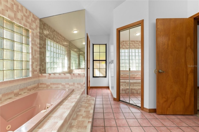 bathroom with tile patterned floors, tiled bath, and plenty of natural light