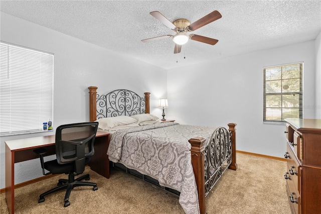 bedroom with ceiling fan, a textured ceiling, and light carpet