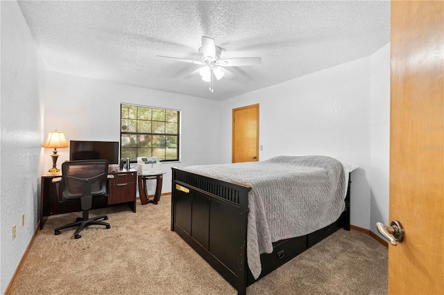 bedroom featuring a textured ceiling, ceiling fan, and light carpet