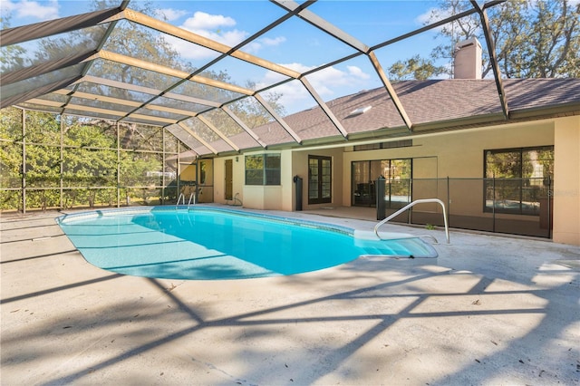 view of pool with glass enclosure and a patio