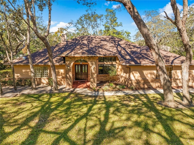 7443 Oak Tree Ln, Spring Hill, FL 34607 - view of front of house featuring brick siding, a front yard, a chimney, and a shingled roof