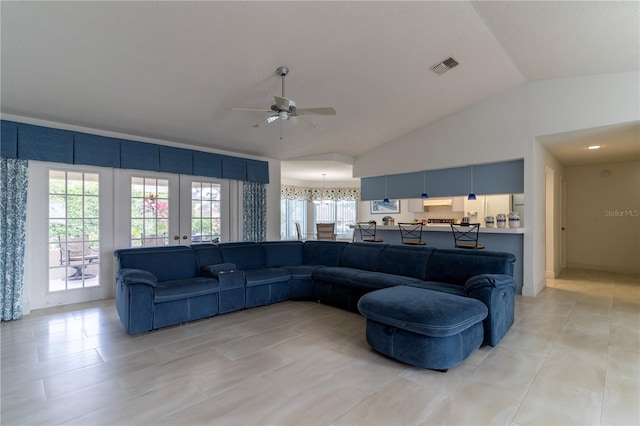 tiled living room with ceiling fan, lofted ceiling, and french doors