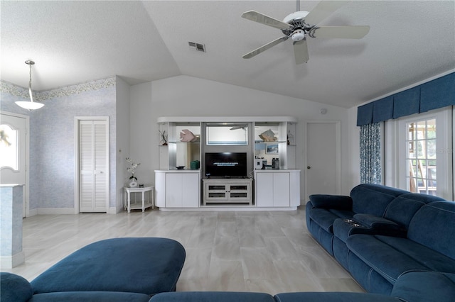 living room with a textured ceiling, ceiling fan, and vaulted ceiling