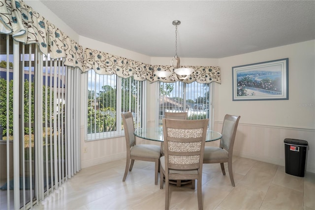 dining room featuring a textured ceiling and a notable chandelier