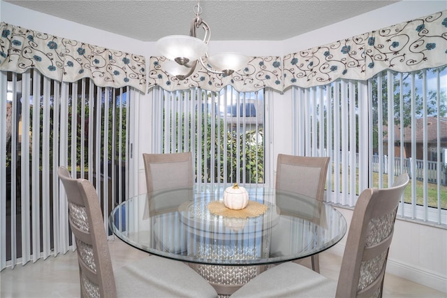 dining room featuring a wealth of natural light, a textured ceiling, and a notable chandelier