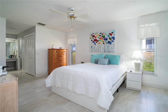 bedroom featuring a textured ceiling, a closet, and ceiling fan