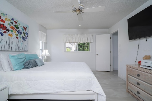 bedroom with a textured ceiling and ceiling fan