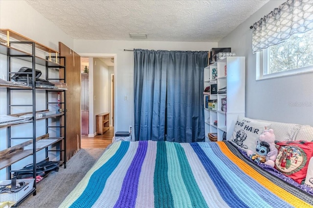 bedroom featuring a textured ceiling and carpet flooring