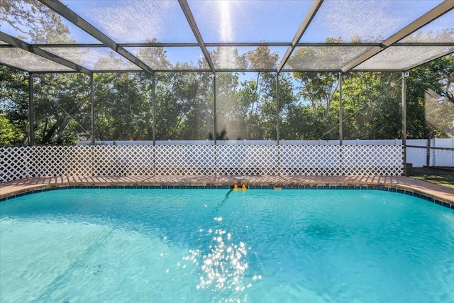 view of swimming pool featuring glass enclosure