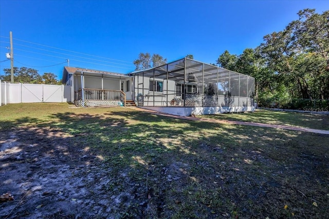 back of property featuring a yard and glass enclosure