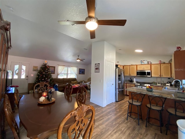 dining space with dark hardwood / wood-style floors, vaulted ceiling, ceiling fan, and sink