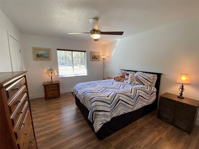 bedroom featuring a textured ceiling, ceiling fan, and dark hardwood / wood-style floors