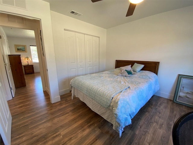 bedroom with ceiling fan, dark wood-type flooring, and a closet