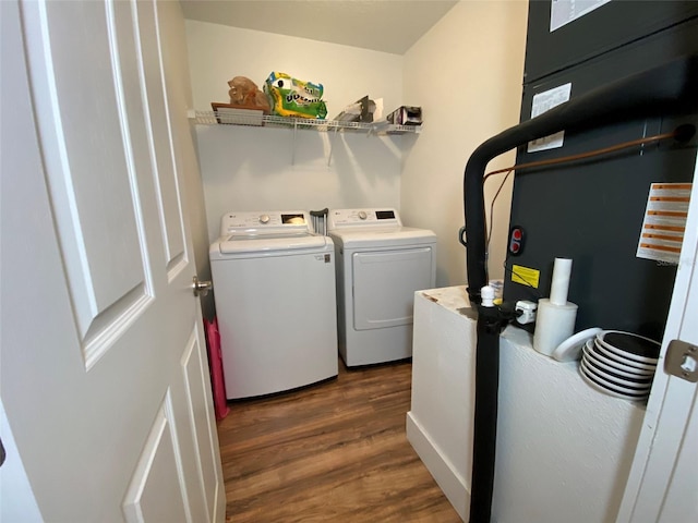 laundry room with washer and clothes dryer and dark wood-type flooring