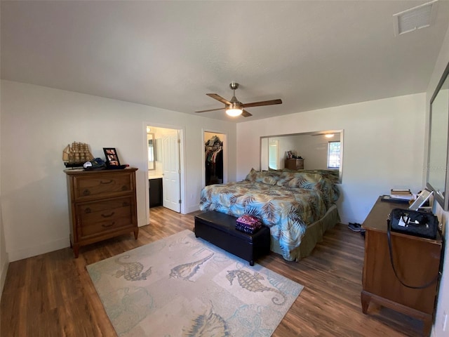 bedroom featuring ceiling fan, ensuite bathroom, wood-type flooring, a walk in closet, and a closet