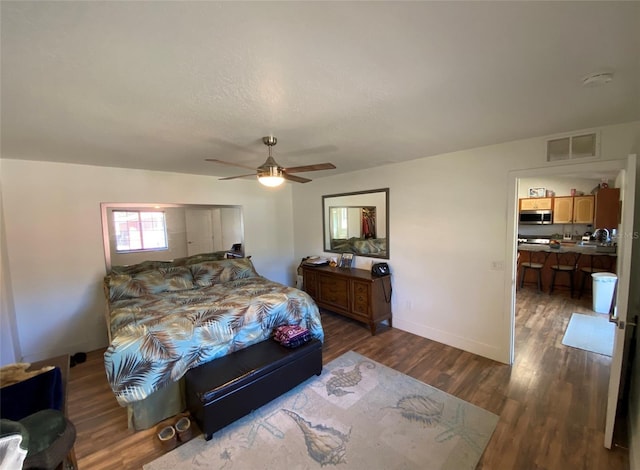 bedroom with ceiling fan and dark wood-type flooring