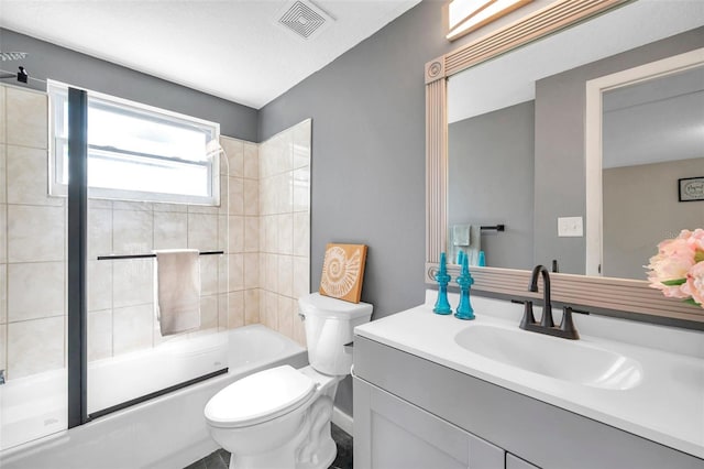 full bathroom featuring vanity, enclosed tub / shower combo, a textured ceiling, and toilet