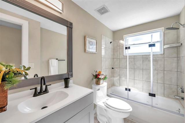 full bathroom featuring vanity, enclosed tub / shower combo, and toilet