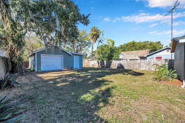 view of yard featuring a garage and an outbuilding