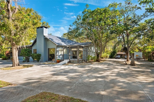 view of front of home with a chimney and stucco siding