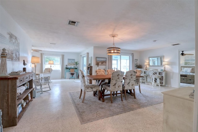 dining space featuring ceiling fan with notable chandelier