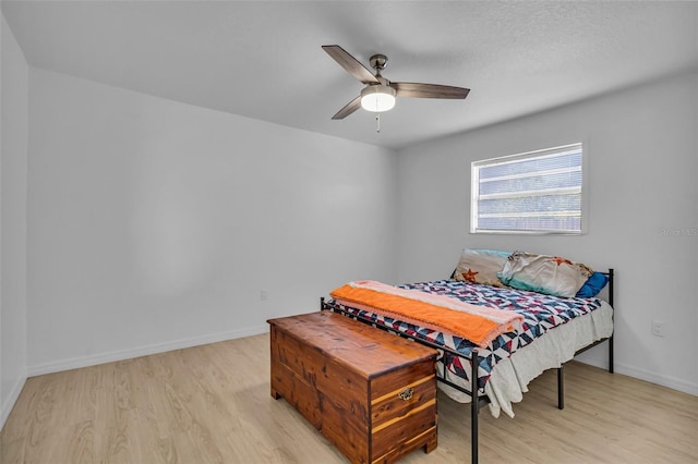 bedroom featuring ceiling fan, light wood-type flooring, and a textured ceiling