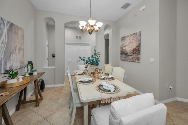 11645 Belle Haven Dr, New Port Richey, FL 34654 - dining space featuring arched walkways, a chandelier, light tile patterned floors, and baseboards