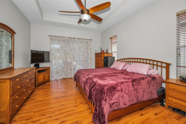 11645 Belle Haven Dr, New Port Richey, FL 34654 - bedroom featuring light wood finished floors, a raised ceiling, and a ceiling fan