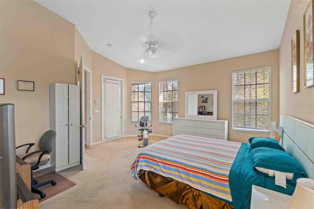 carpeted bedroom featuring multiple windows and ceiling fan