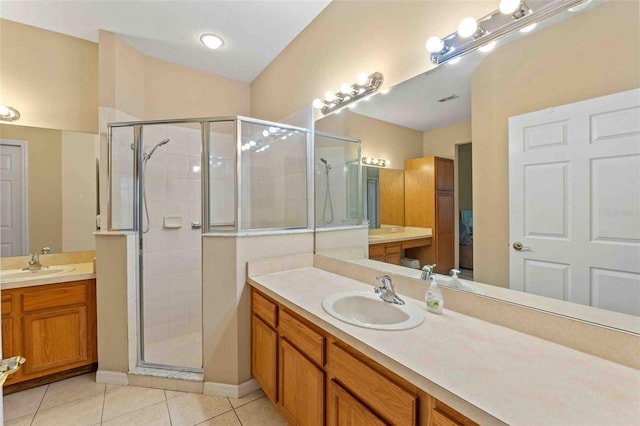 bathroom with tile patterned flooring, vanity, and walk in shower